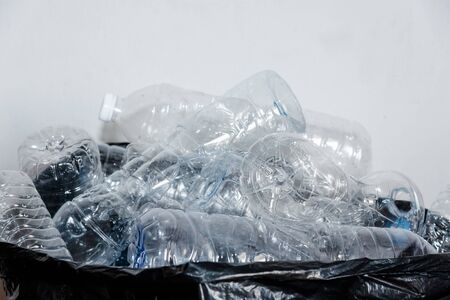 Plastic bottles in black garbage bags waiting to be taken to recycle.の写真素材