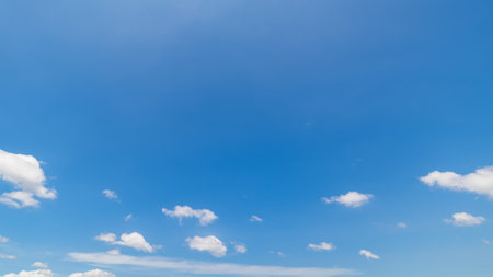 Panoramic view of clear blue sky and clouds, Blue sky background with tiny clouds. White fluffy clouds in the blue sky. Captivating stock photo featuring the mesmerizing beauty ofの写真素材