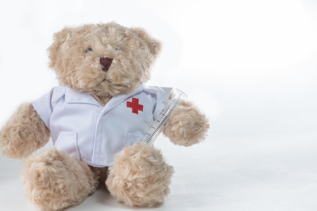 Bear Red Cross holding syringe on white background. (injection needle)の写真素材