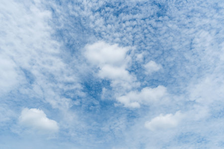 Panoramic view of clear blue sky and clouds, Blue sky background with tiny clouds. White fluffy clouds in the blue sky. Captivating stock photo featuring the mesmerizing beauty ofの写真素材
