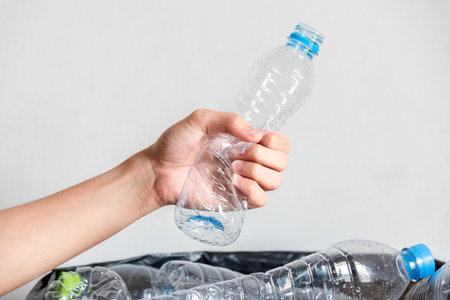 Plastic bottles in black garbage bags waiting to be taken to recycle.の写真素材