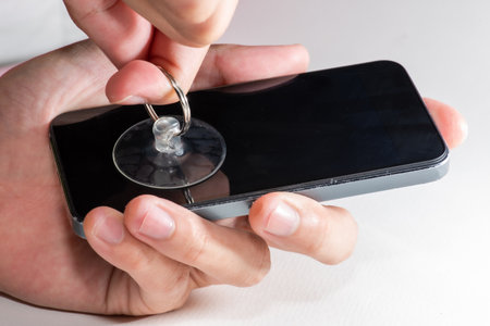 The smartphone was damages and need to repair  which tools smartphone that stand isolated on white background by hands of repairman.の写真素材