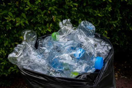 Plastic bottles in black garbage bags waiting to be taken to recycle.