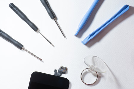 The smartphone was damages and need to repair  which tools smartphone that stand isolated on white background by hands of repairman.の写真素材
