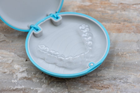 Clear aligner device in the mouth on a white background.の写真素材