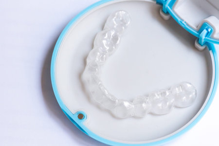 clear aligners device in the mouth on a white background. (invisalign)