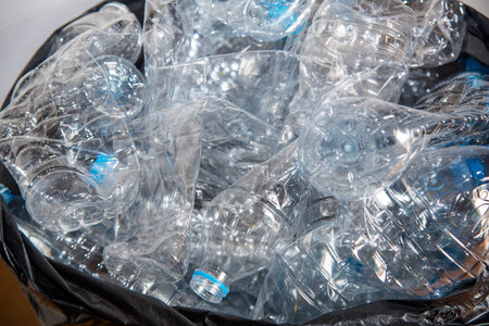 Plastic bottles in black garbage bags waiting to be taken to recycle.