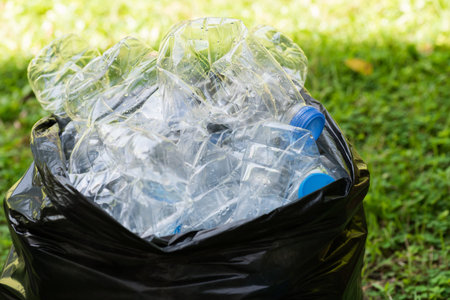 Plastic bottles in black garbage bags waiting to be taken to recycle.の写真素材