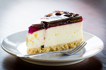 Blueberry cheesecake in white plate on wood tableの写真素材
