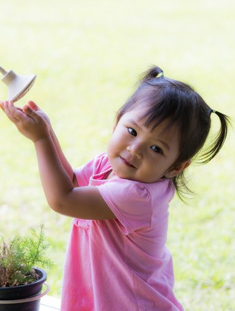 Cute little girl is playing old shower in the parkの写真素材