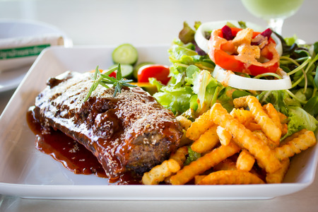 BBQ Ribs - Marinated pork ribs with salad, french fries and barbeque sauce.の写真素材