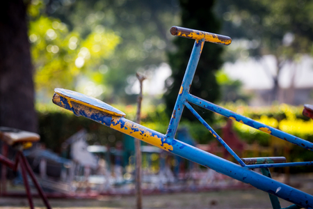 Blue seat of old and rusty iron seesaw on playgroundの写真素材