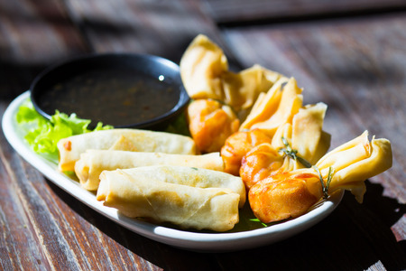 Fried wonton and spring rolls served with sweet sauceの写真素材