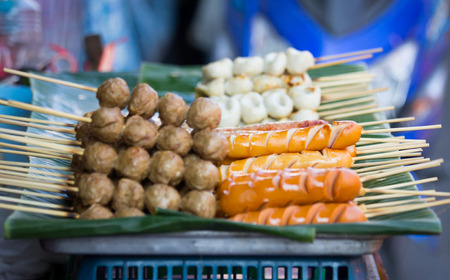 Grilled hotdogs and grilled meatball on banana leaf, Thai street foodの写真素材