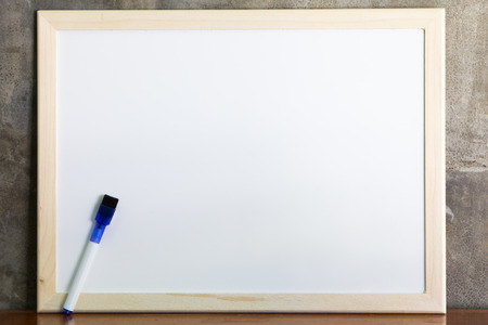 Whiteboard and marker on cement wall backgroundの写真素材