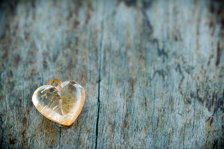 Crystal heart on wood table in vintage styleの写真素材