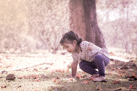 Cute little girl is playing in the park in vintage styleの写真素材
