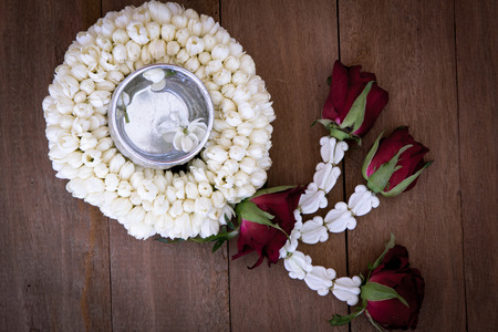 Beautiful Thai garland flowers (jasmine and roses) and water in bowl (Use for Songkran festival in Thailand)の写真素材