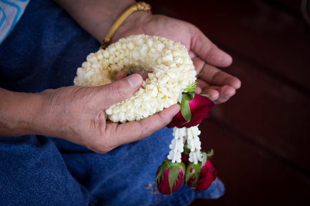 Woman hand holding jasmine garland in Songkran festival