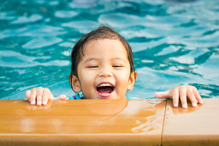Cute little girl having fun in the swimming poolの写真素材