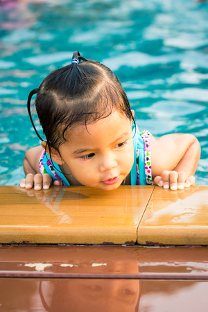 Cute little girl having fun in the swimming poolの写真素材