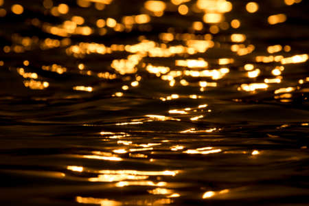 Pool water wave with gold bokeh of sunset light in eveningの写真素材
