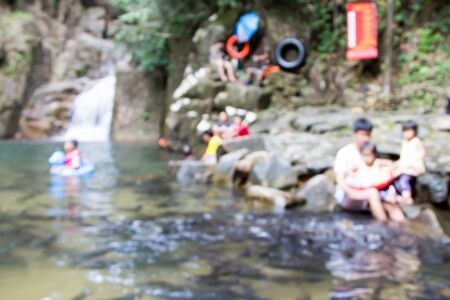 Blurred image of people play water and fish feeding in public waterfallの写真素材