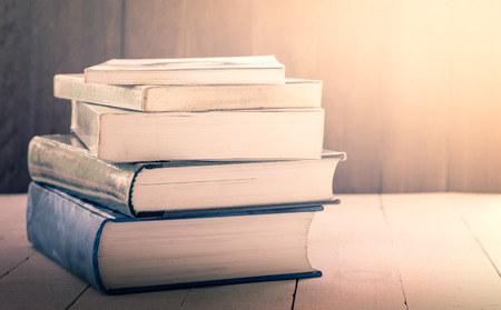 stack of old books on wooden table,vintage color filterの写真素材