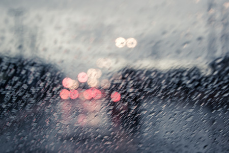 blurred image of traffic view through a car windscreen covered in rain,vintage filterの写真素材