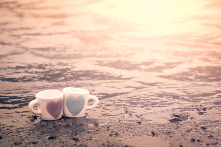 two lovely glass on sand of lake in vintage  color toneの写真素材