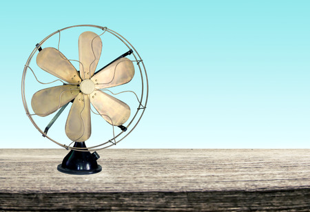 vintage metal fan on wooden table front green backgroundの写真素材