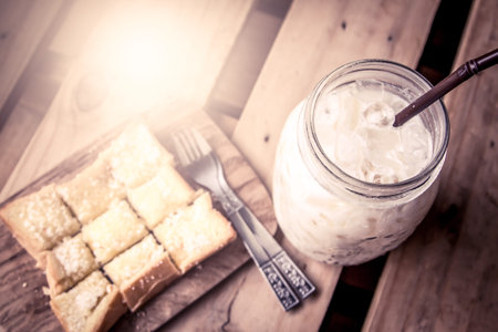 top view of milk with sweet toast on wooden table in vintage color toneの写真素材