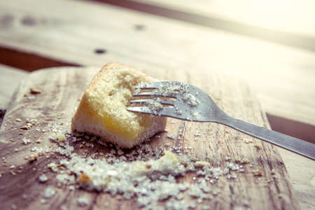 fork on piece of sweet toast with sugar on wooden plate in vintage color toneの写真素材