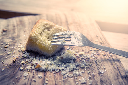 fork on piece of sweet toast with sugar on wooden plate in vintage color toneの写真素材