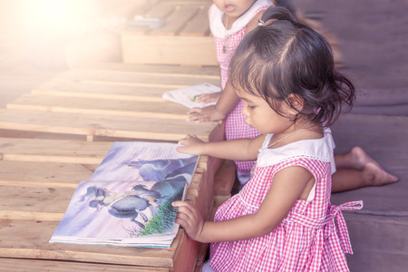 cute little girl reading books in library,vintage filterの写真素材