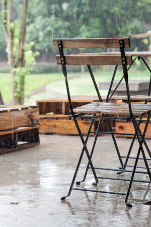 Wooden table and chair in garden in rainy dayの写真素材