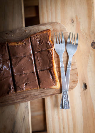 top view of chocolate sweet toast with fork on wooden tableの写真素材