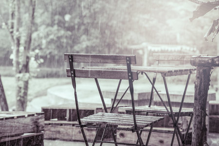 Wooden table and chair in garden in rainy day,vintage filterの写真素材