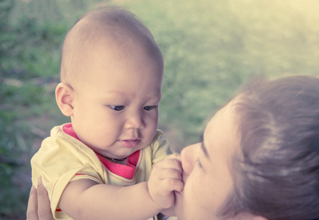 Cute little boy playing with mother in the park in soft color filterの写真素材
