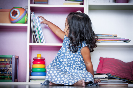 Child read, cute little girl reading a book and sitting on floor,vintage filterの写真素材