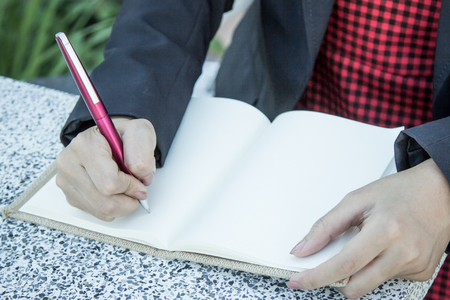 Woman hand writing her notebookの写真素材