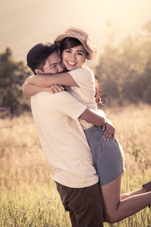 Young couple in love  in the meadow in vintage color filterの写真素材