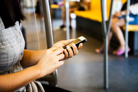 Woman using smartphone, cellphone in subwayの写真素材