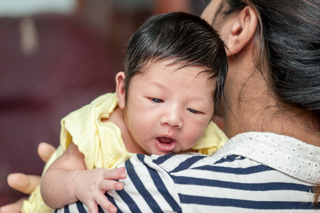 Cute newborn baby boy on his mother shoulderの写真素材