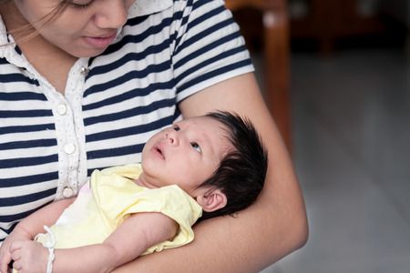 Cute newborn baby boy is lying on mother arm  in vintage color toneの写真素材