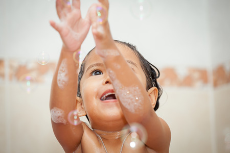 Child cute little girl bathing and playing with bubble in the bathroomの写真素材