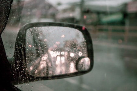 blurred rain drop on car window in rainy day in dark tone