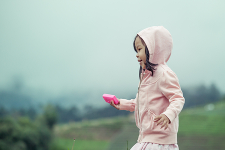 Child cute little girl  running in the garden after rain in vintage color toneの写真素材
