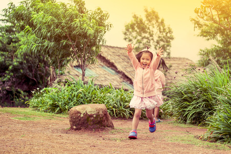 Child happy little girl  running and having fun in the garden in vintage color toneの写真素材