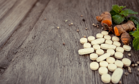 Medicine herb, Herbal pills with healthy medicinal plant on wooden backgroundの写真素材